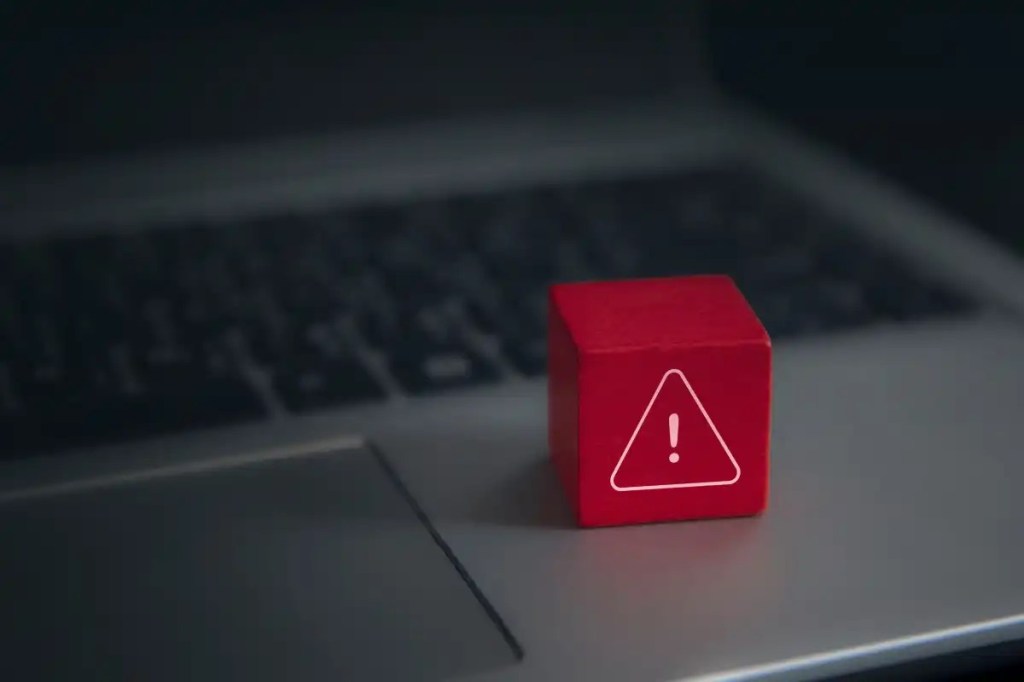 Red-warning-cube-on-a-laptop-keyboard-in-darkened-room-1