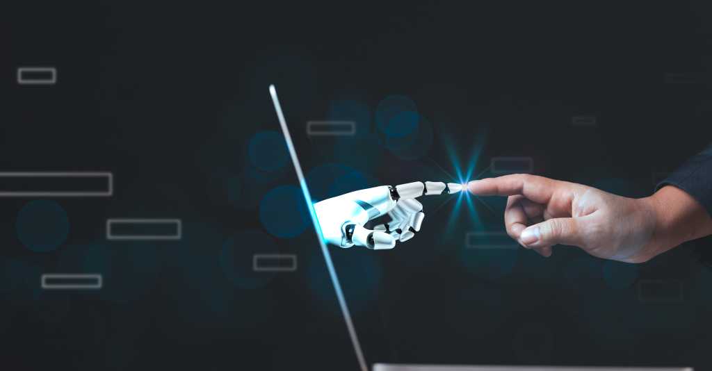 A human finger touches an android finger through a laptop interface.