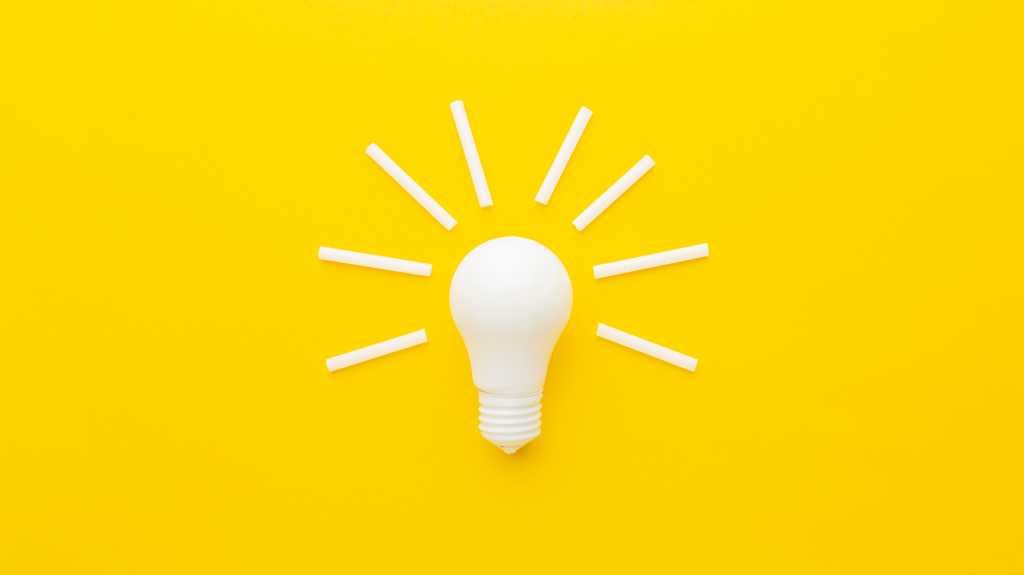 shutterstock 2408848757 white light bulb and white sticks of chalk on bright yellow background
