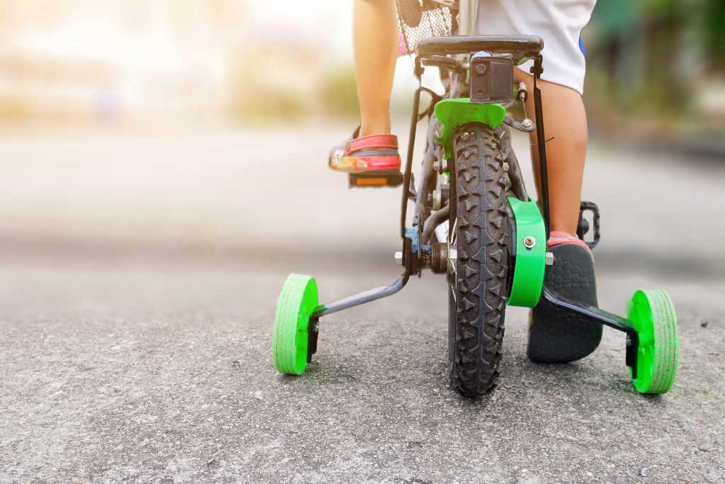 shutterstock 1175637019 learning to ride a bike training wheels
